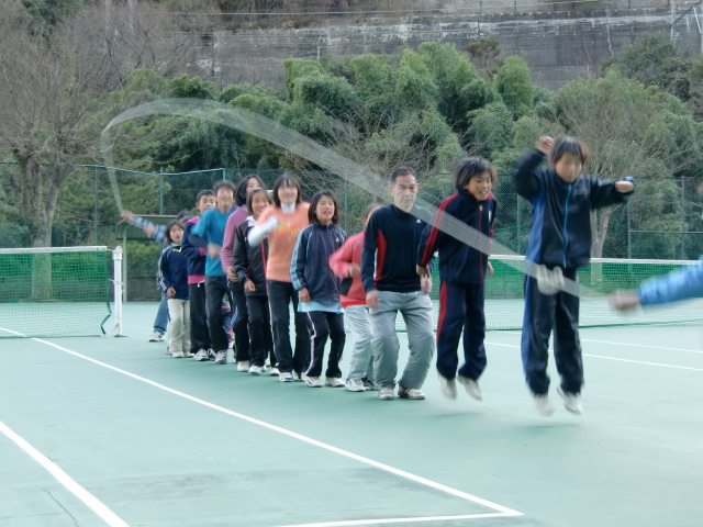 テニスコートで縄跳びする選手たち