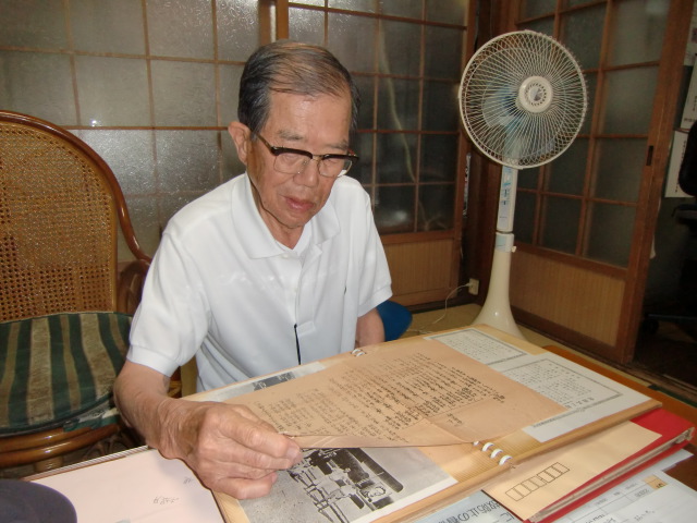 古いアルバムから見つかった「橋本町国民義勇隊」組織図などを見る阪口さん
