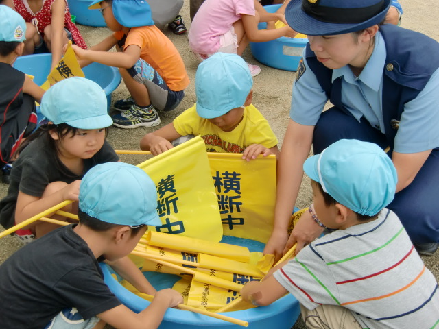 成川巡査の指導で横断旗を洗濯する園児たち