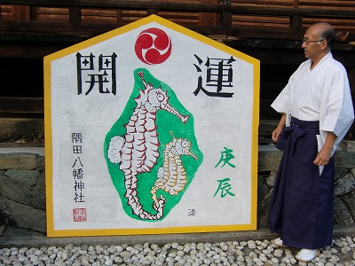 山内さんが奉納した〝辰の大絵馬〟を見る隅田八幡神社の禰宜・寺本さん